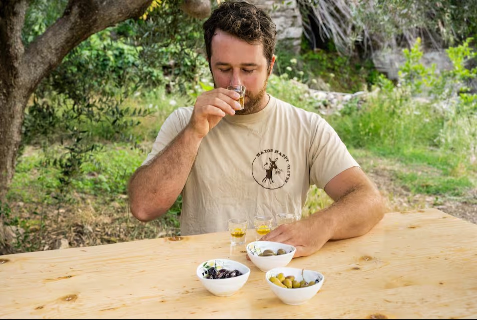 Host tasting olive oil with olives and bowls